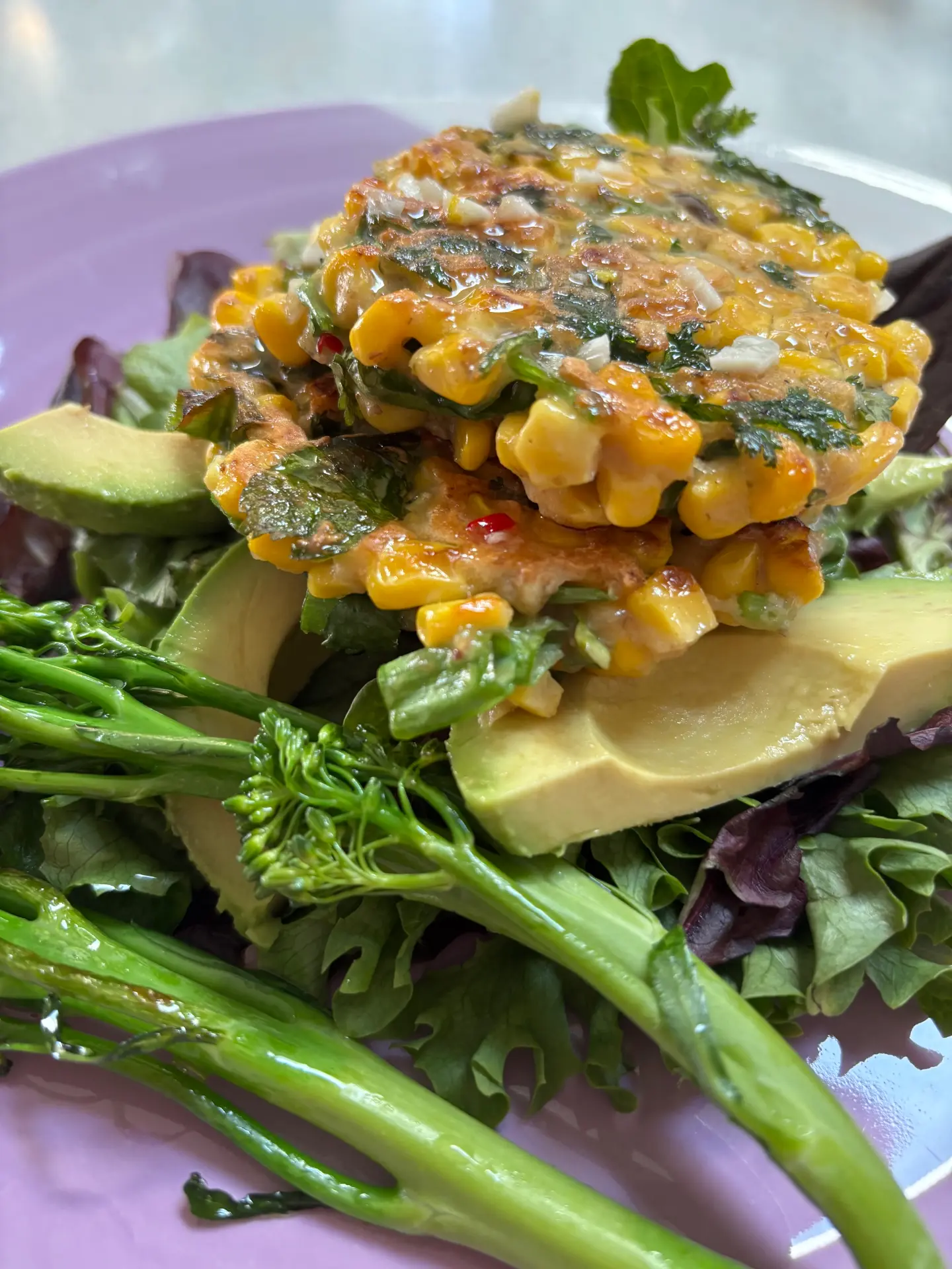 Golden corn fritters served on salad with dipping sauce