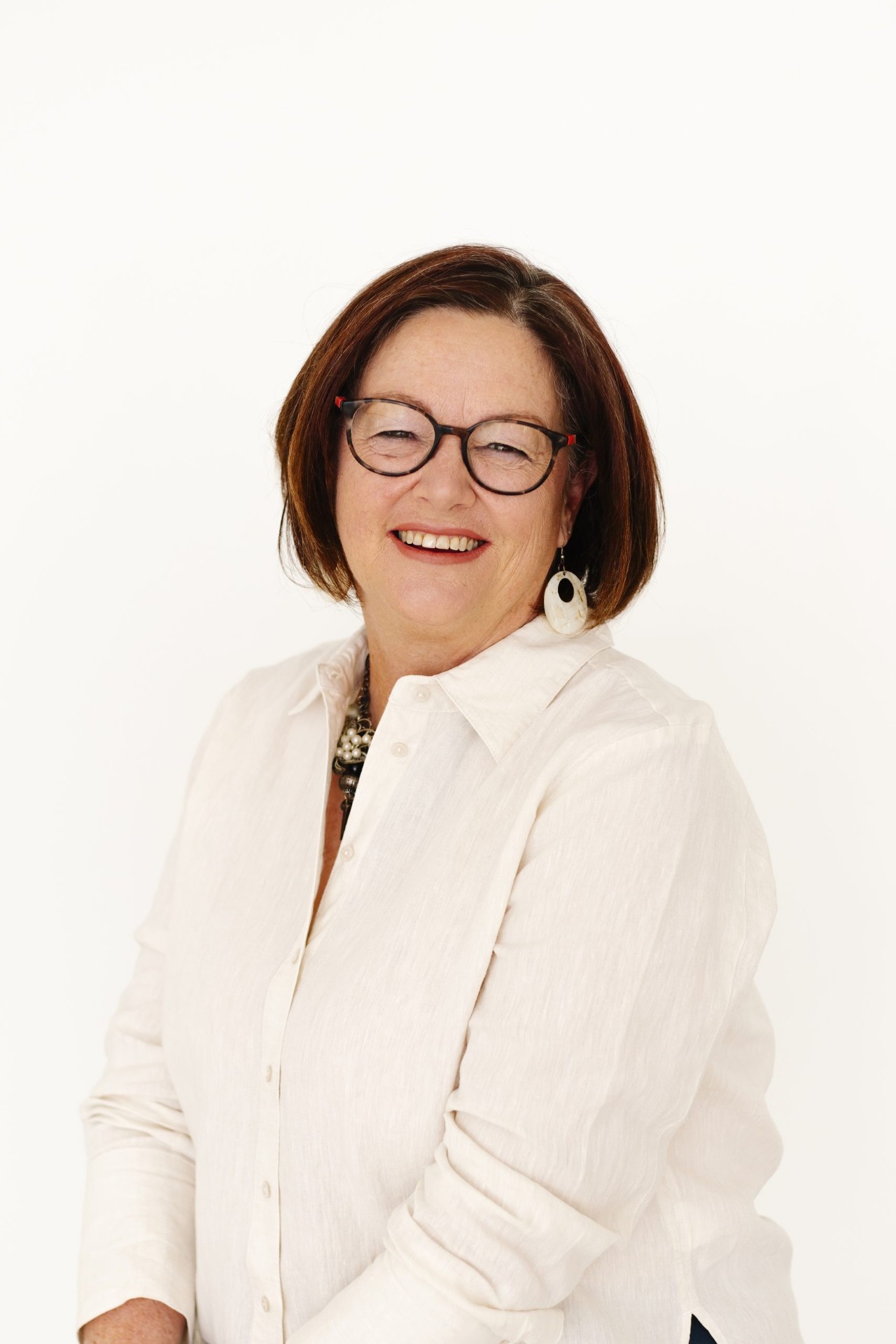 Naturopath Sharon Hespe smiling, wearing a white linen shirt