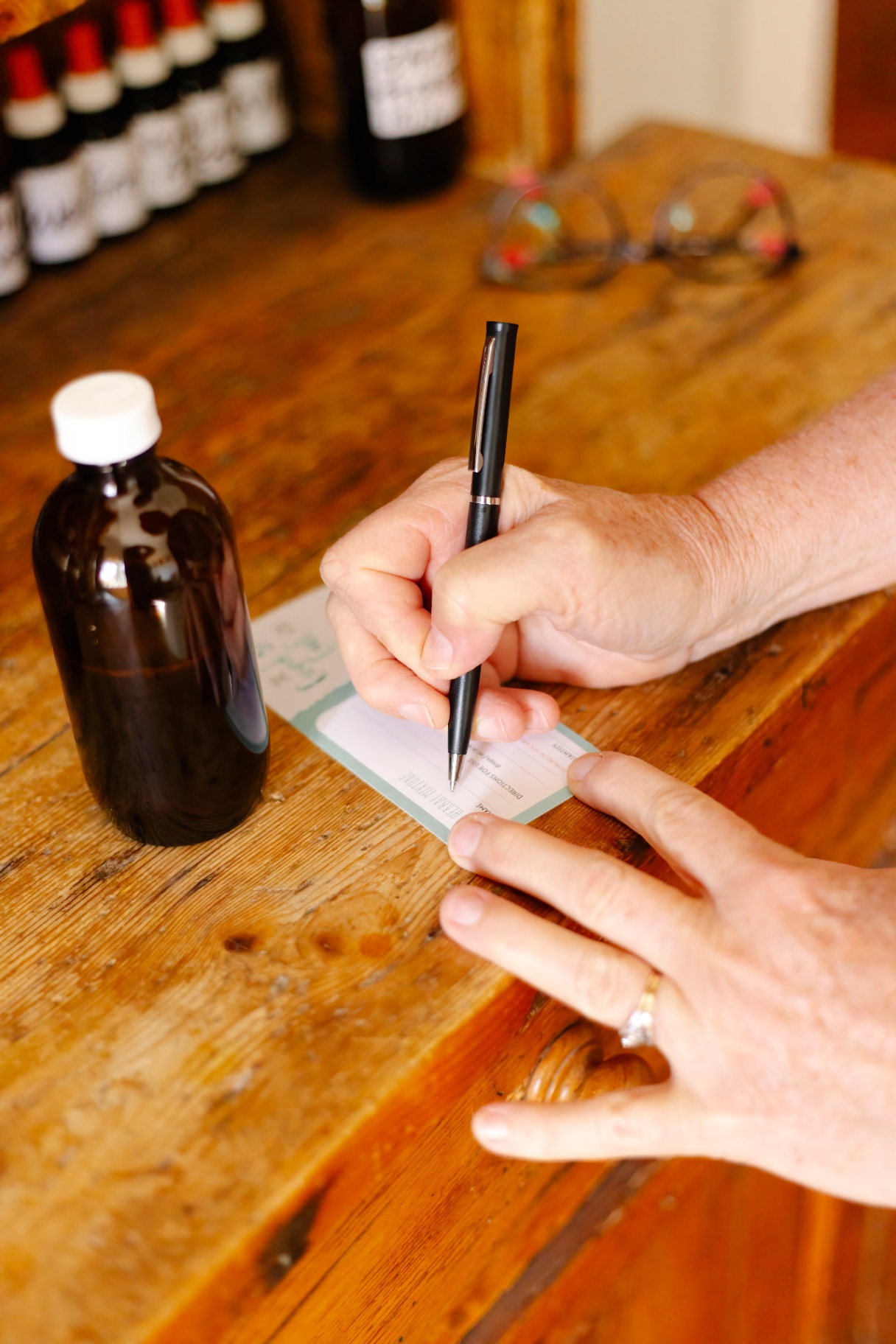 Sharon handwriting a herbal prescription label